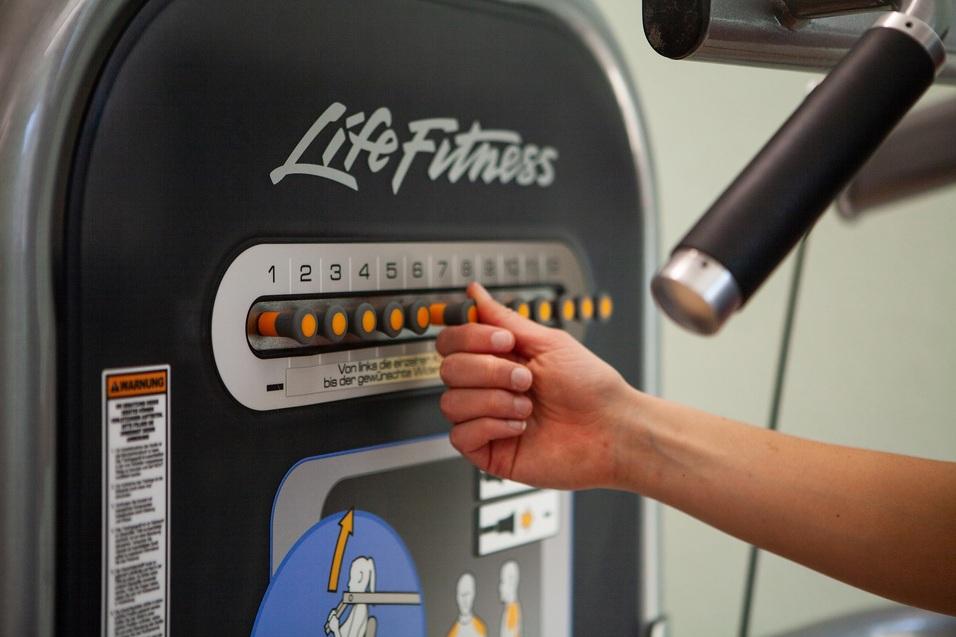 Nahaufnahme einer Hand, die einen Trainingswiderstand an einem Life Fitness-Gerät einstellt.